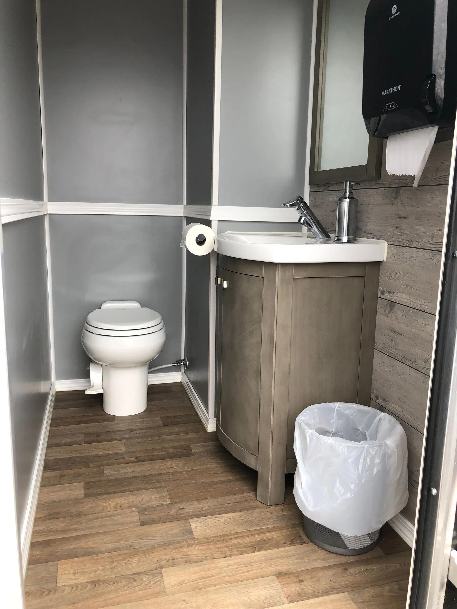 Toilet and sink setup inside finished portable restroom